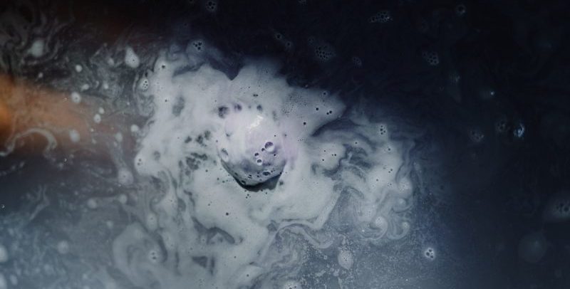dark blue bath bomb dissolving in water