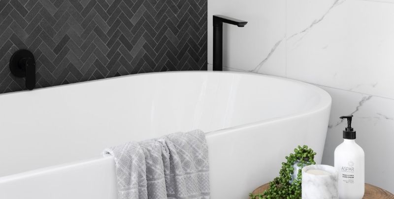 white freestanding bath tub with black tap