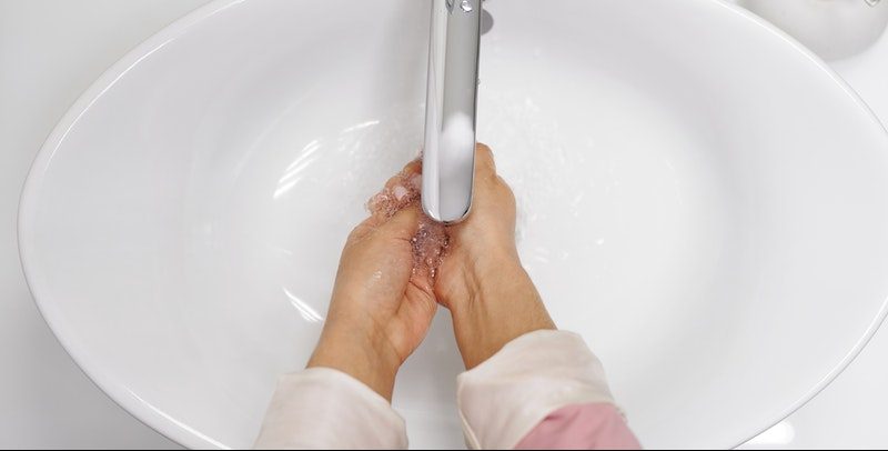 person washing their hands in the sink
