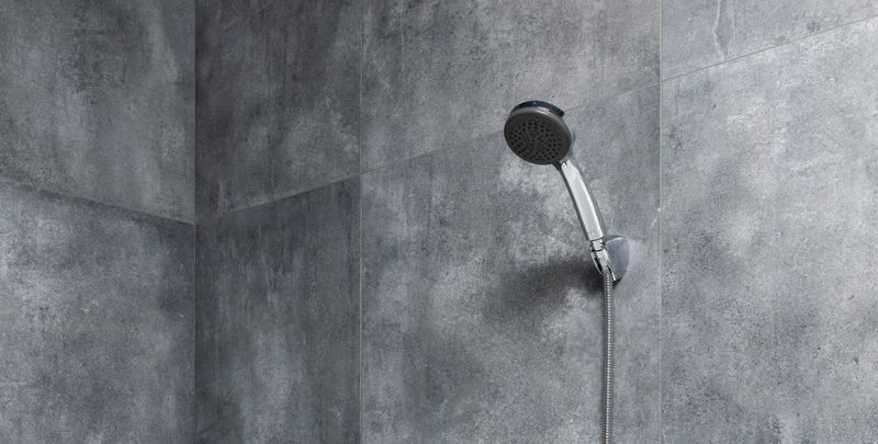 handheld shower head in grey bathroom