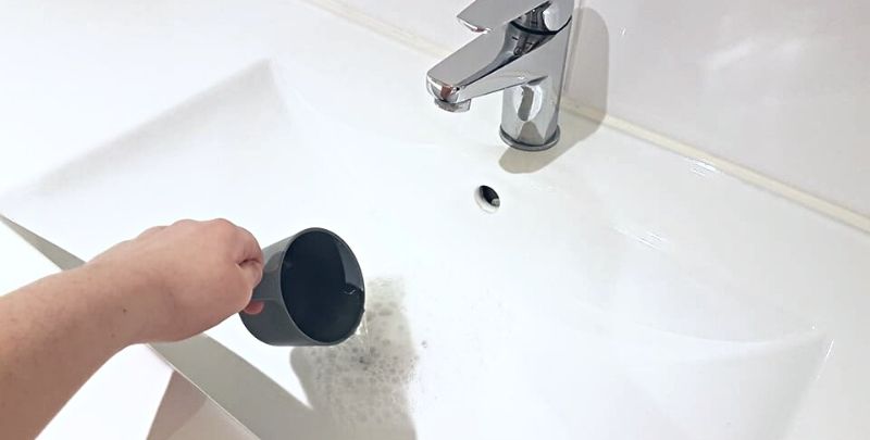 pouring 1 cup of vinegar down sink drain