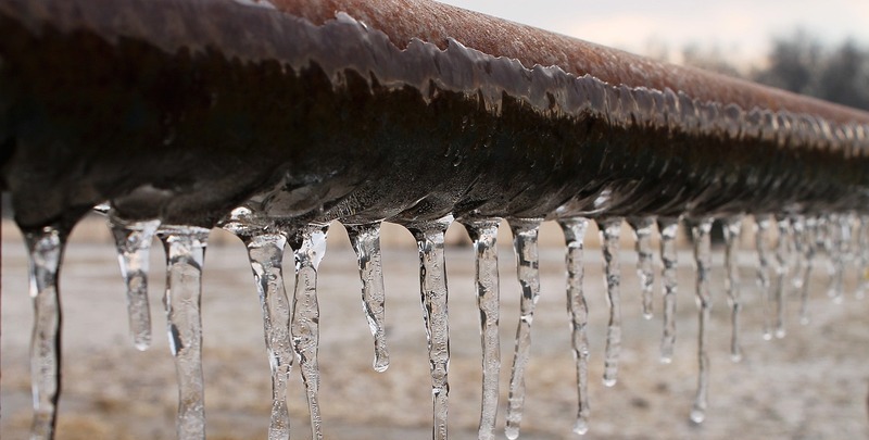 Icicles forming on an old pipe. Freezing is a major cause of burst pipes.