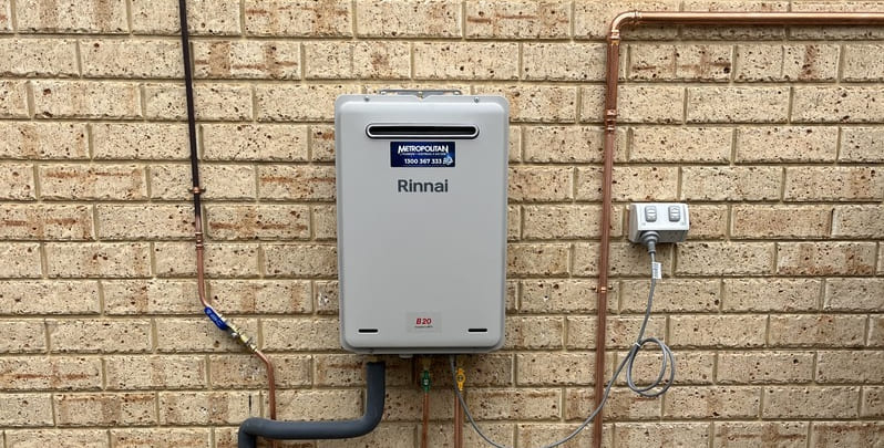 hot water system fixed to brick wall of home