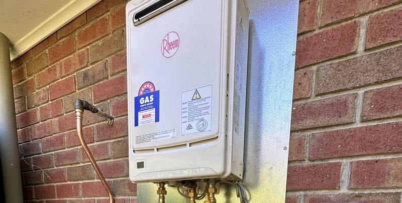 gas hot water system fixed to the brick wall of a home